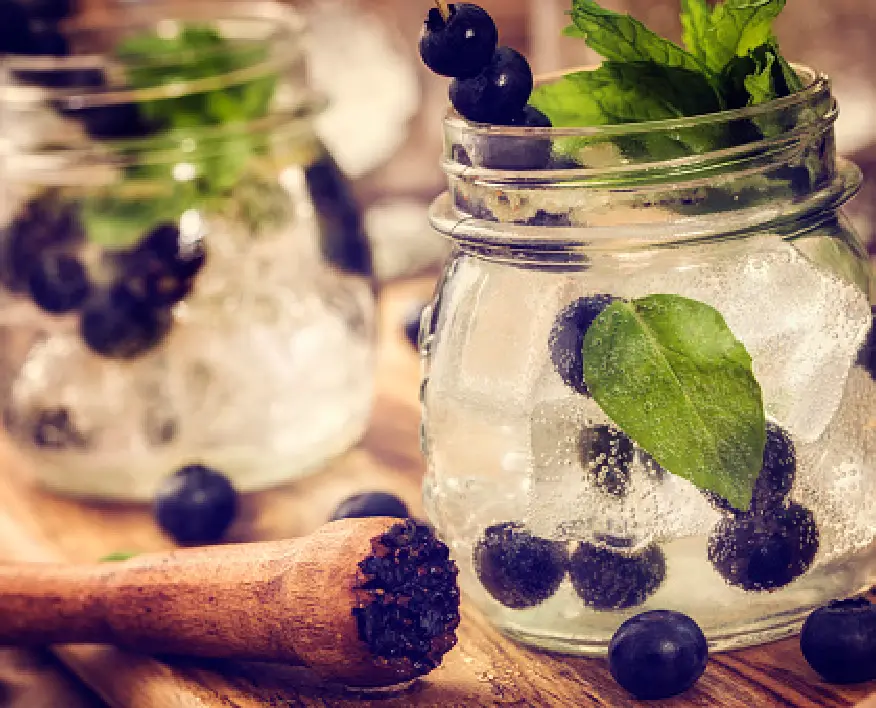Blueberry Non-Alcoholic Cocktail with fresh fruit & wooden masher