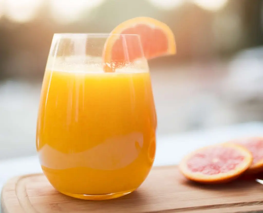Orange and lime non-alcoholic cocktail on wooden board